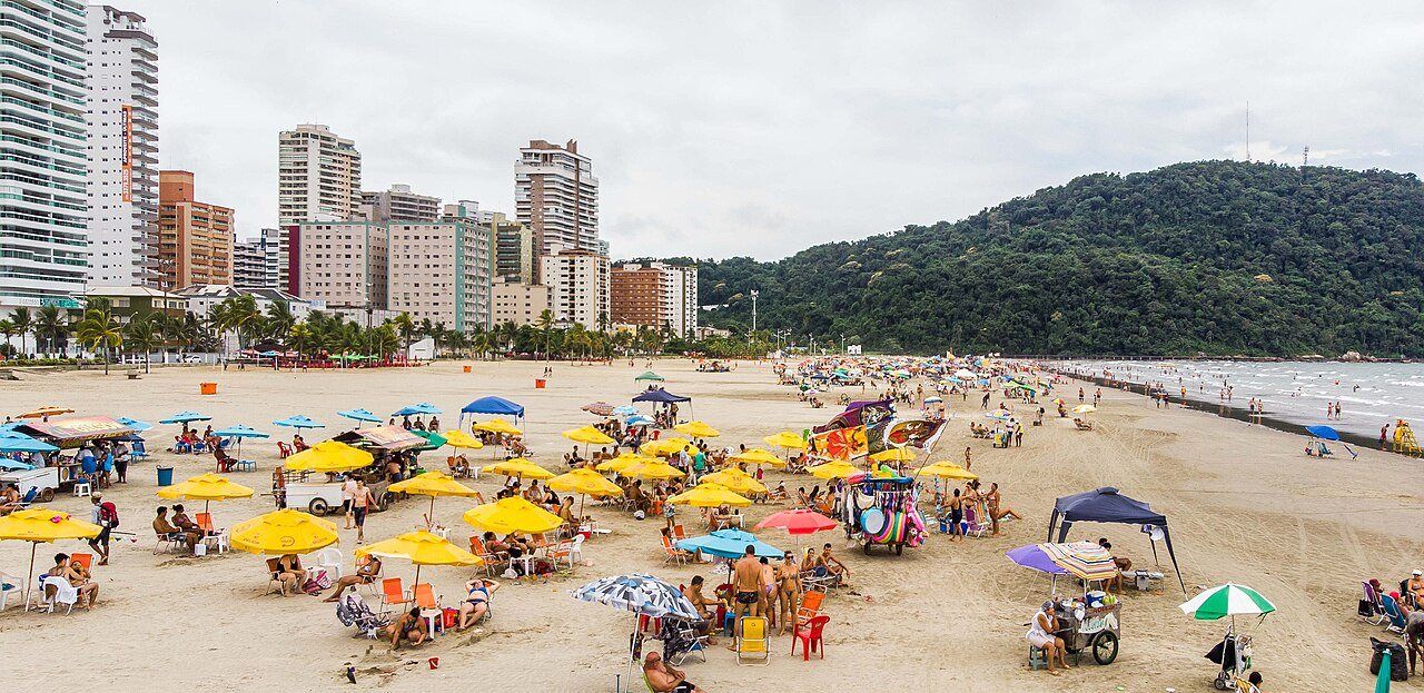 Praia do Canto do Forte com prédios e o morro ao fundo